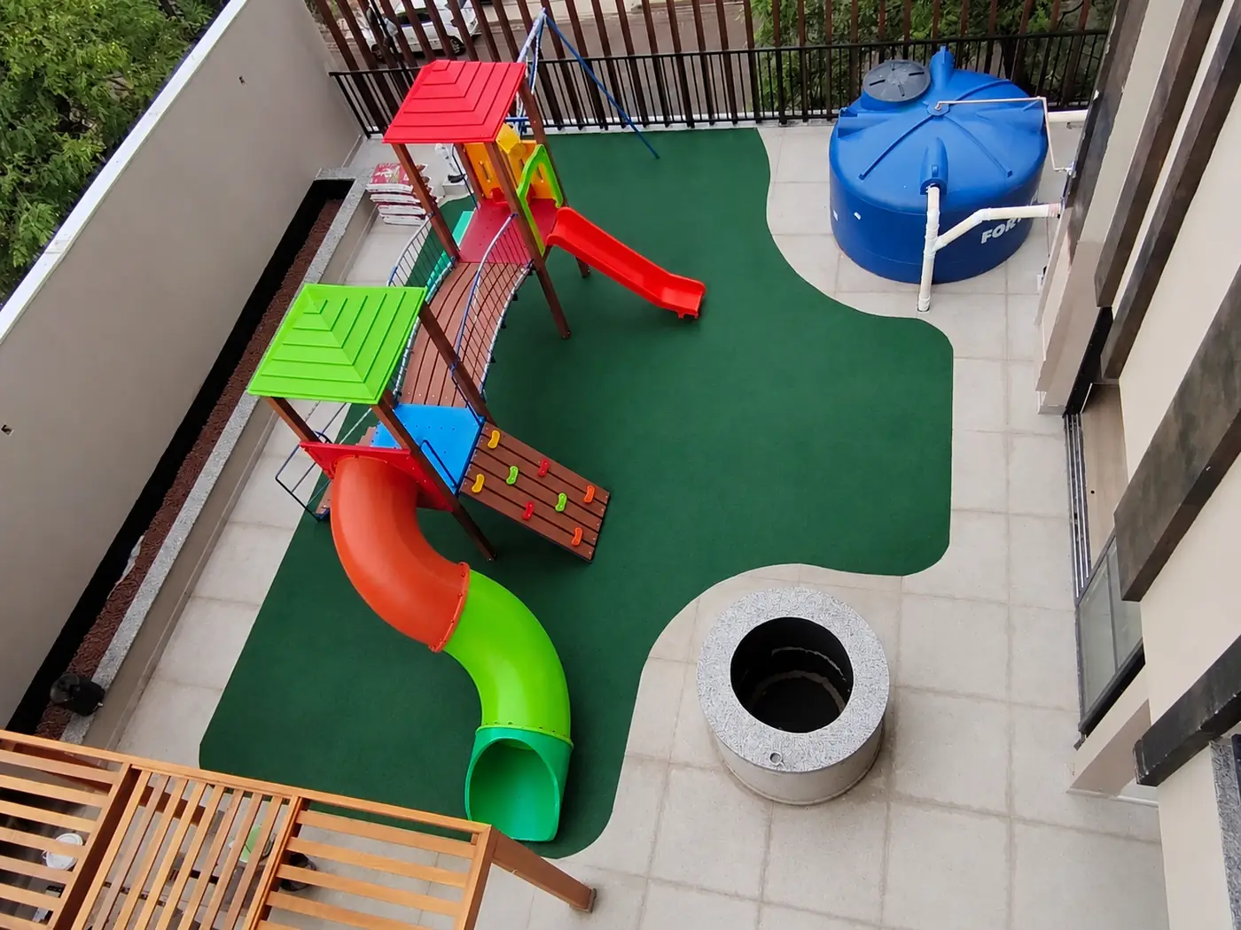 Playground em varanda de prédio com piso monolítico SBR verde no Atto Sette House Club, Maringá/PR