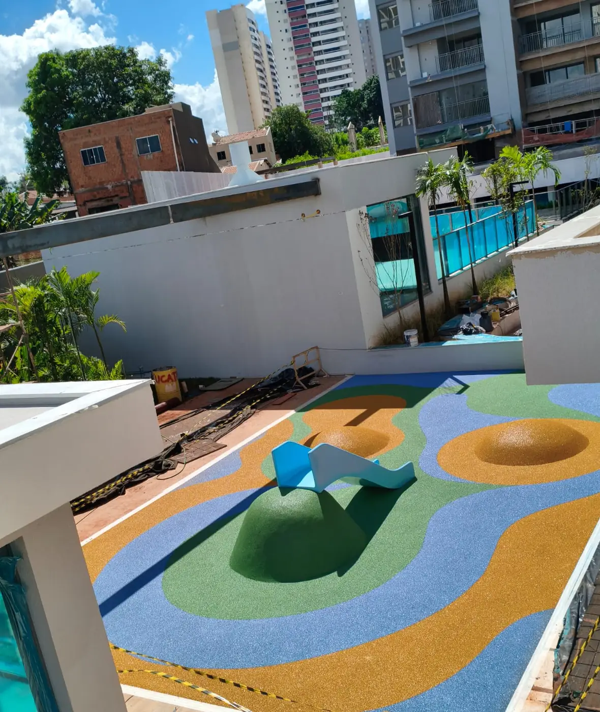 Morrote médio com escorregador sobre piso monolítico de borracha colorido