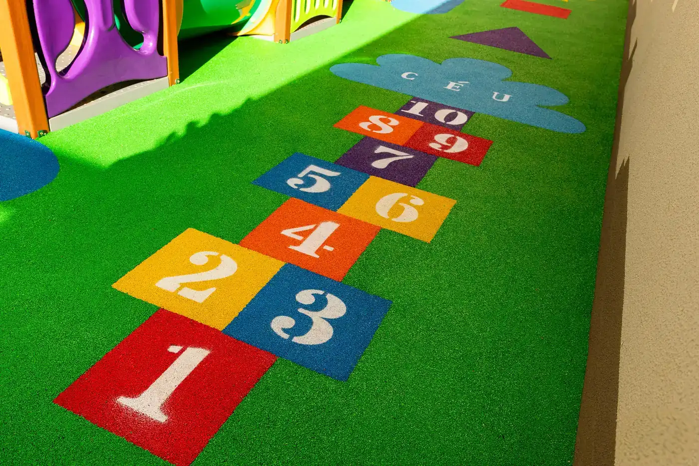 Amarelinha tradicional numerada em EPDM colorido sobre piso verde