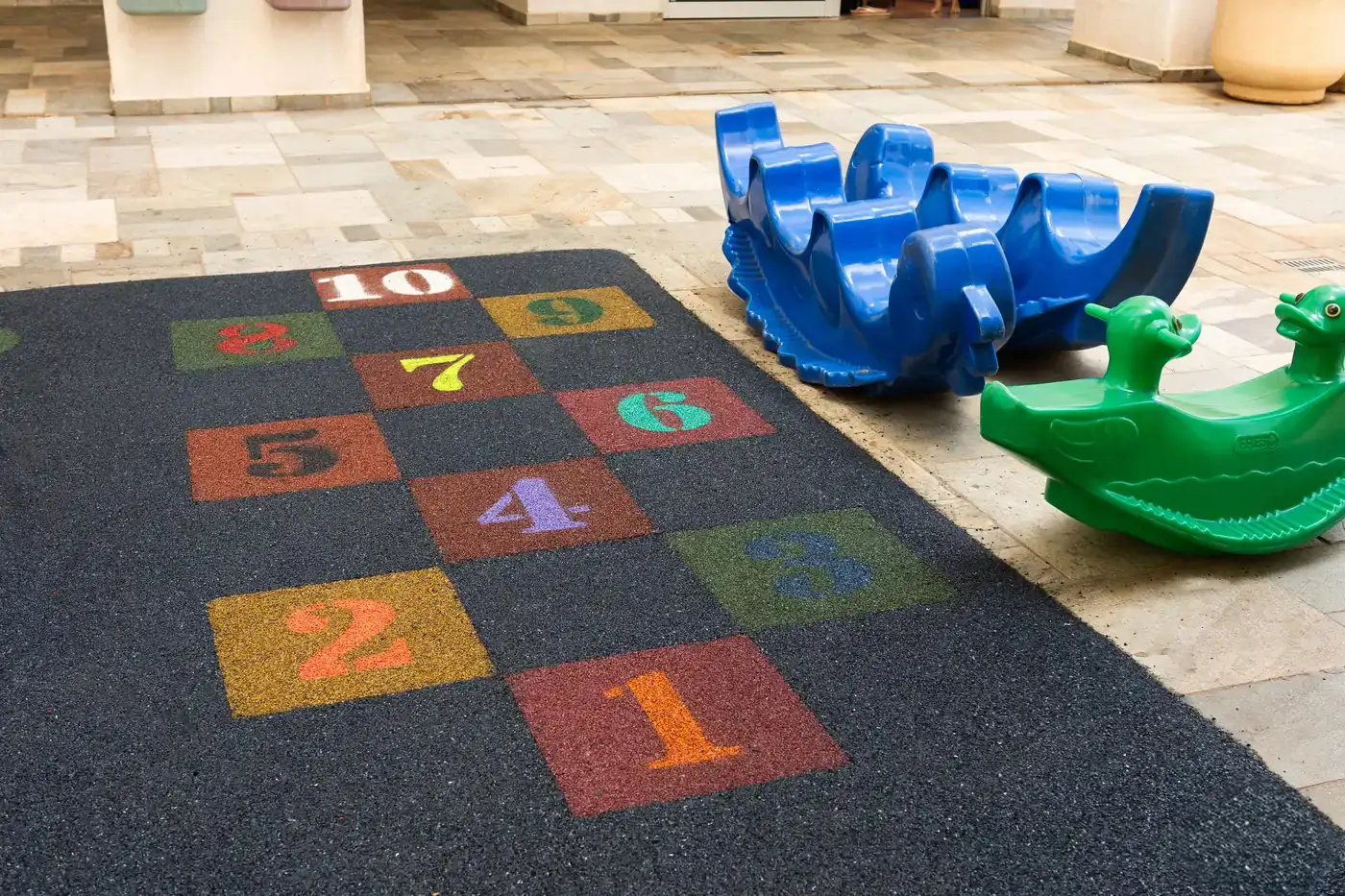 Amarelinha numerada em borracha colorida sobre piso monolítico SBR cinza