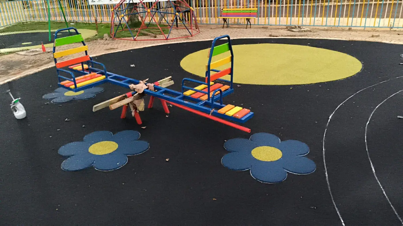 Flores em borracha colorida integradas ao piso monolítico escuro