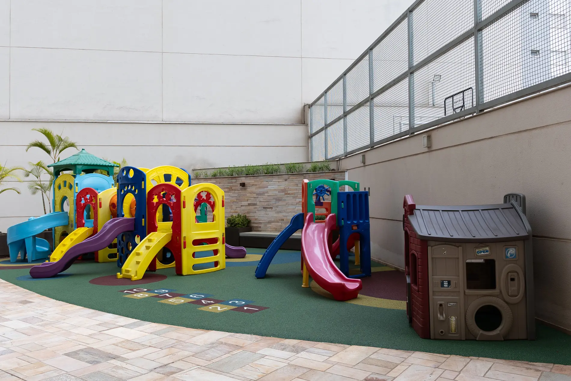 Playground com piso monolítico SBR verde e amarelinha integrada no Condomínio Maison Unique, Londrina/PR