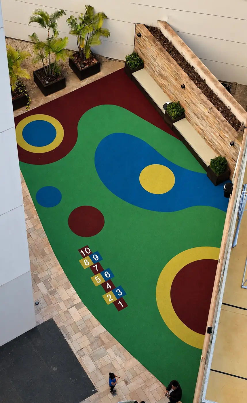 Vista de cima do playground do Condomínio Maison Unique com piso monolítico SBR verde e vinho em Londrina/PR