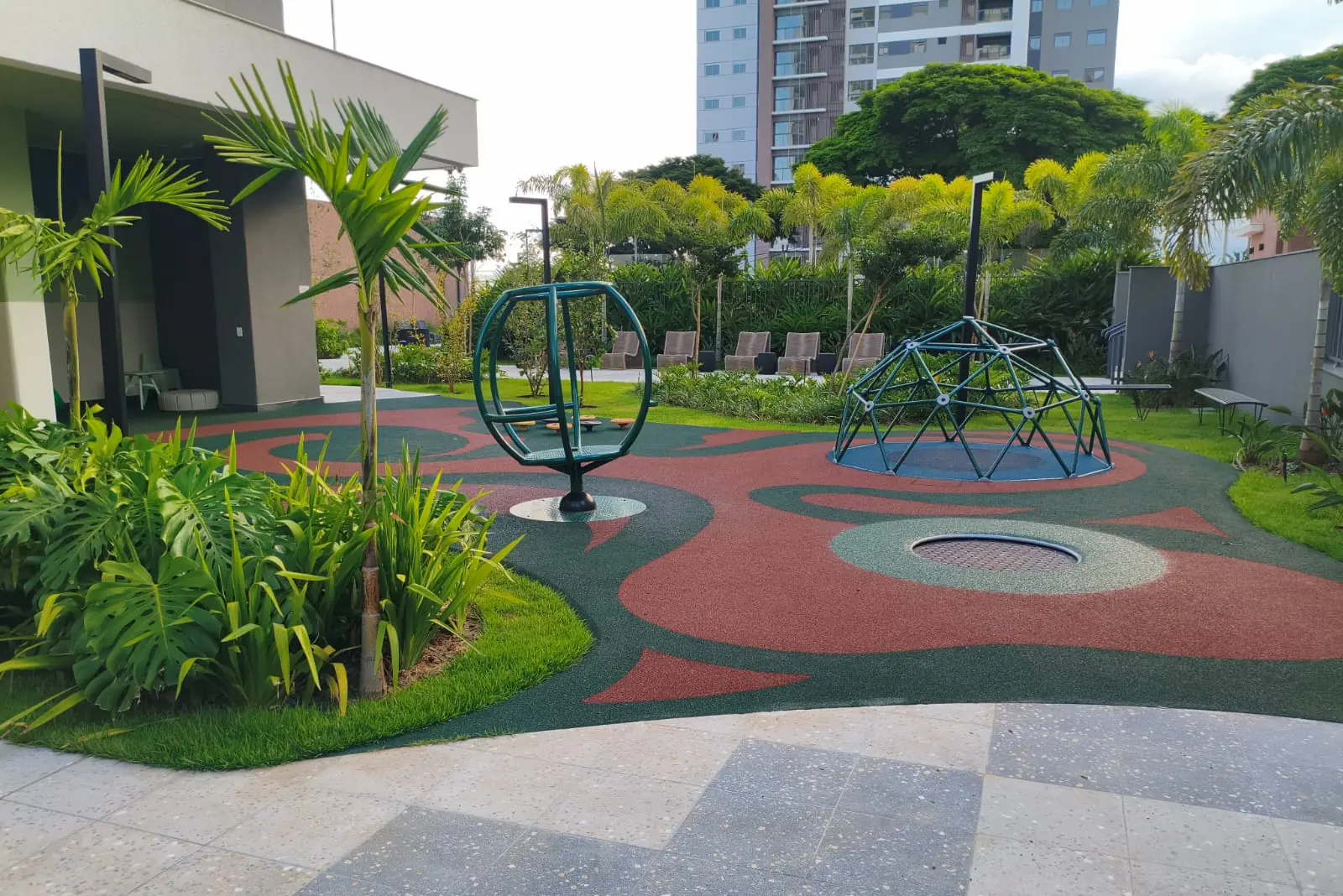 Área de lazer com piso monolítico SBR em desenho orgânico vermelho e verde no Empreendimento Sense da Vanguard, Londrina/PR