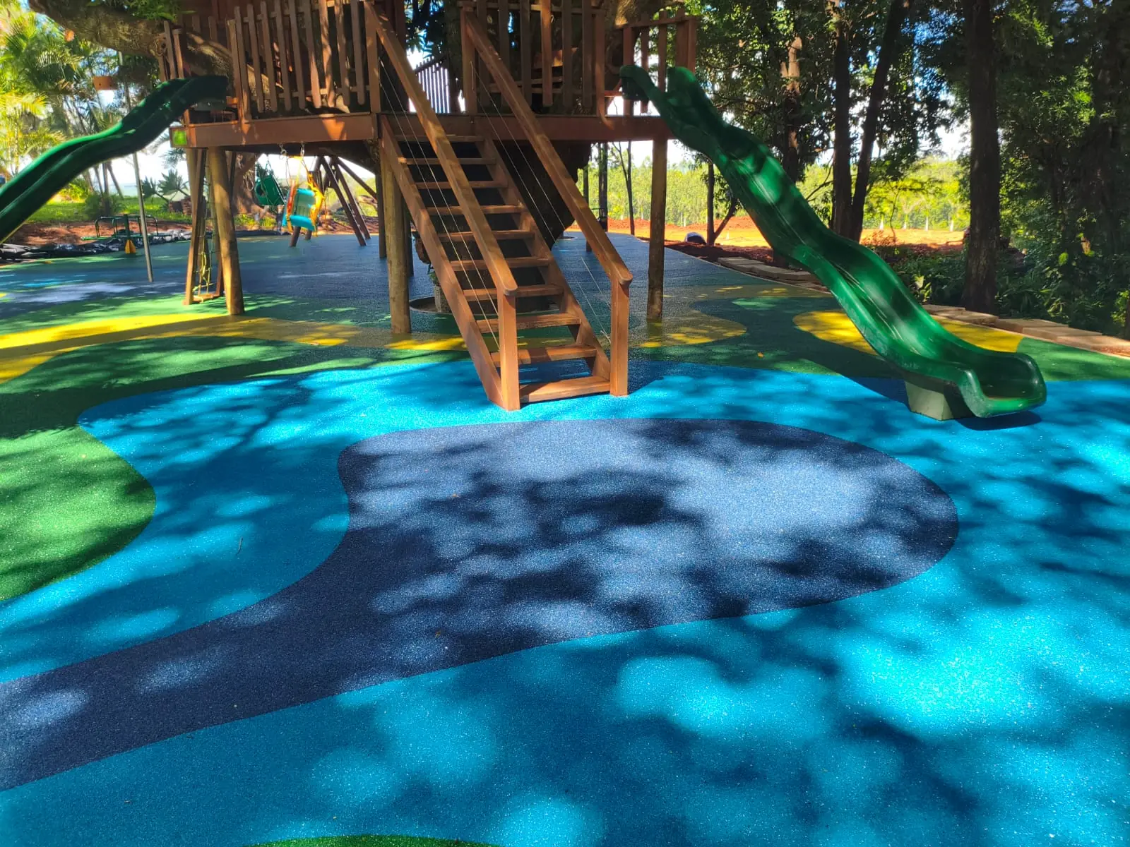 Playground de madeira sobre piso monolítico SBR azul e verde na Fazenda Tília, Rolândia/PR